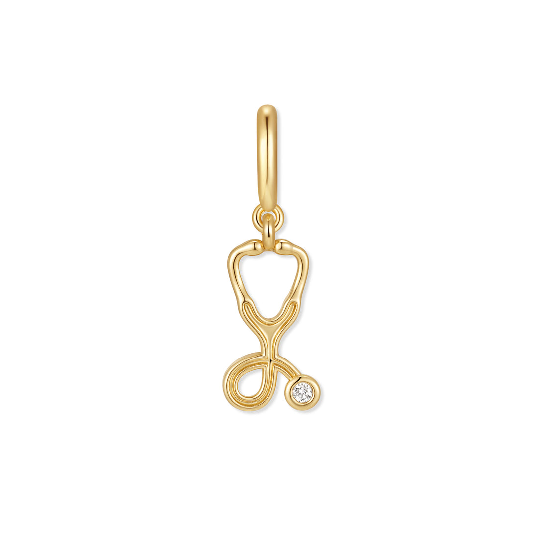 Gold-tone stethoscope charm with a bezel-set round diamond accent and a polished ring clasp at the top.