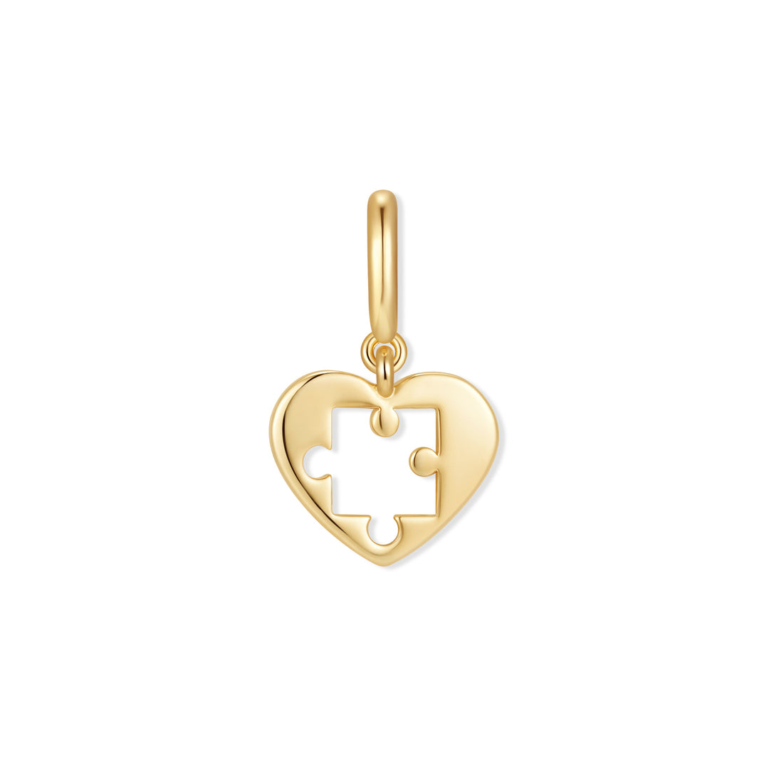 Gold-tone heart charm with a puzzle-piece cutout, suspended from a polished ring clasp.