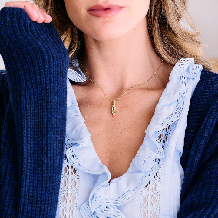Peas in a Pod pendant necklace with a polished pod charm, worn by a model.