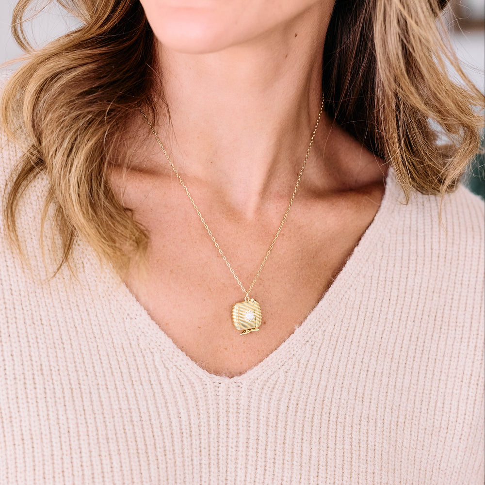 Love Note locket necklace with a ribbed square pendant and star-set diamond accent, worn by a model.