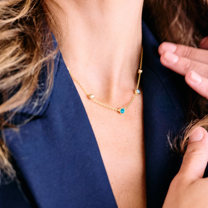 gold rolo chain with floating bezel set birthstones.