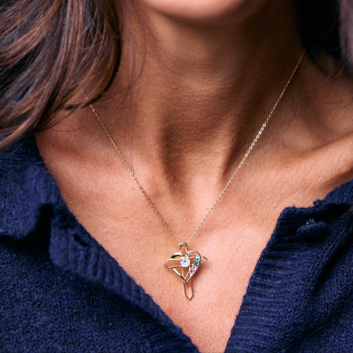 Birthstone Heart and Cross Necklace with an open heart pendant and round birthstones on a chain, worn by a model