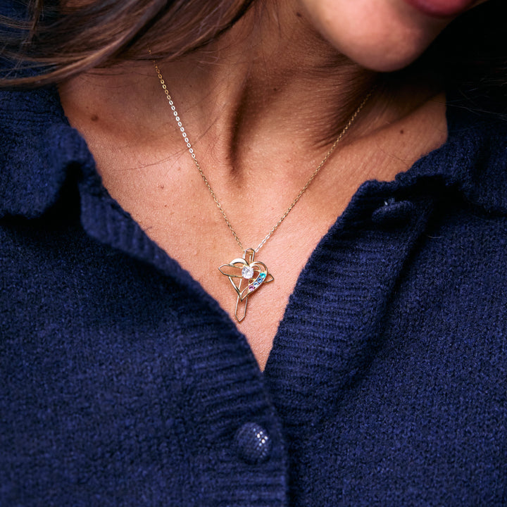 Birthstone Heart and Cross Necklace with an open heart pendant and round birthstones on a chain, worn by a model