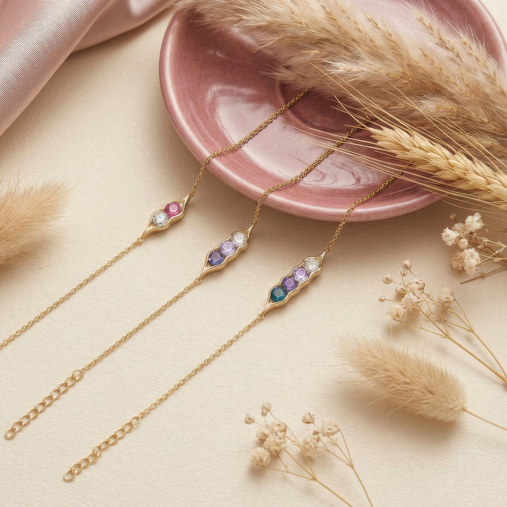 gold rolo chain bracelet with gold pea pod with birthstones.
